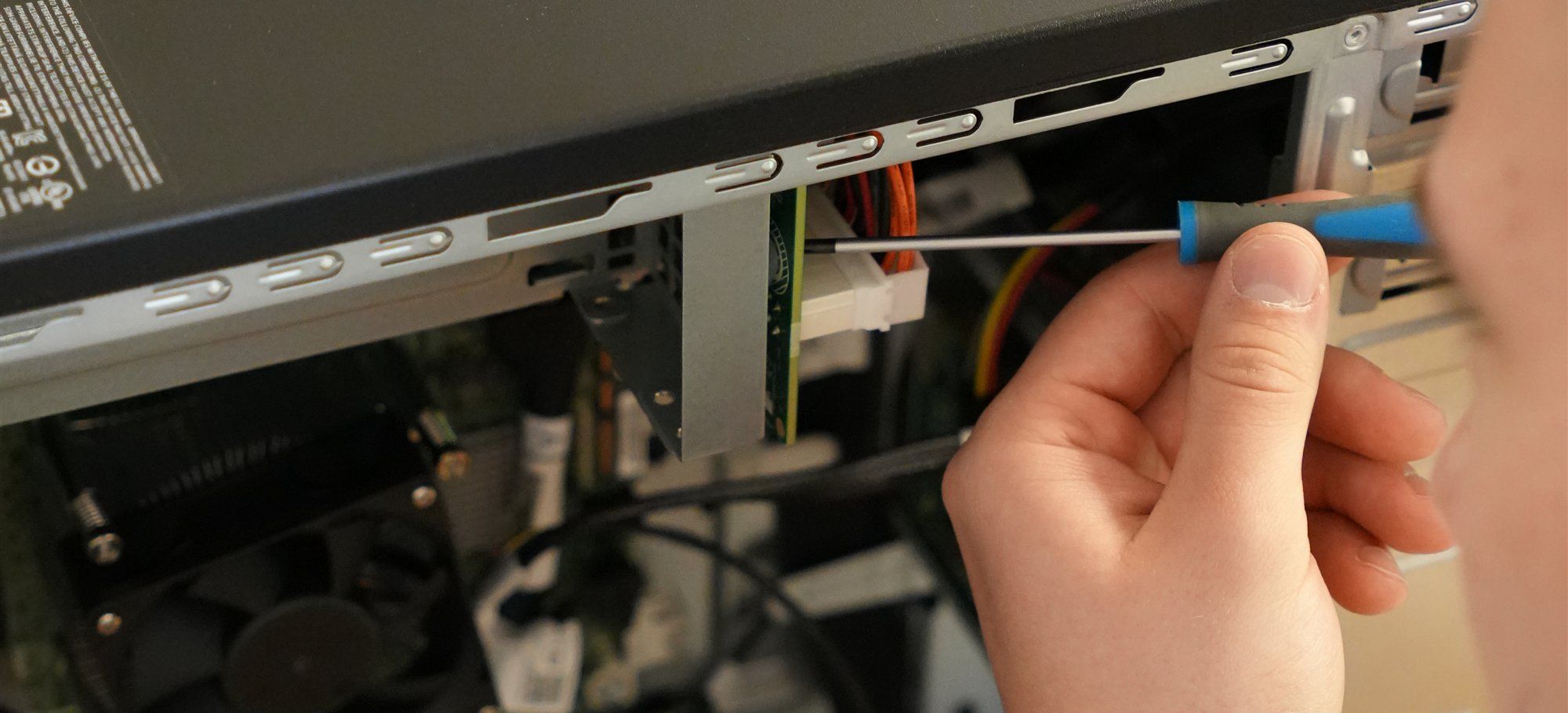 Hand eines Holzer-Technikers mit Schraubendreher im geöffneten Gehäuse eines Servers