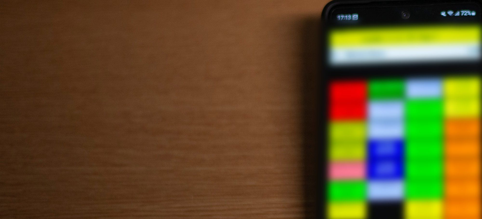 Smartphone mit Bonier-Oberfläche und farbigen Artikeltasten auf einem Holztisch, daneben ein mobiler Bondrucker