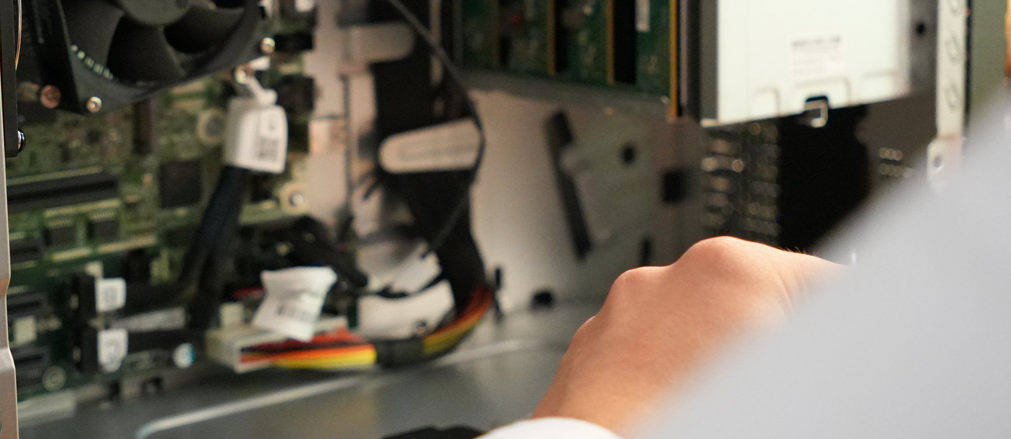 Hand eines Holzer-Technikers bei der Reparatur im geöffneten Gehäuse eines Computers